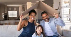 Family under cardboard roof for insurance claim post